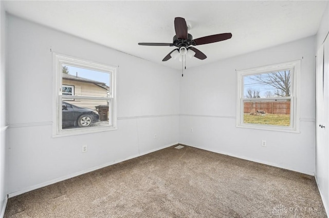 carpeted spare room featuring a ceiling fan