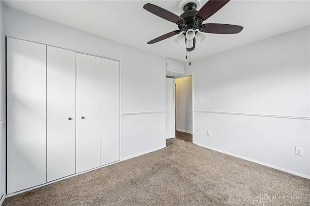 unfurnished bedroom featuring a ceiling fan, a closet, carpet flooring, and baseboards