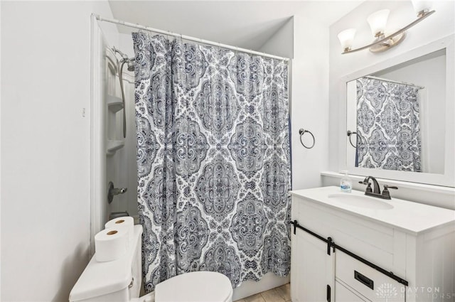 bathroom with curtained shower, vanity, and toilet