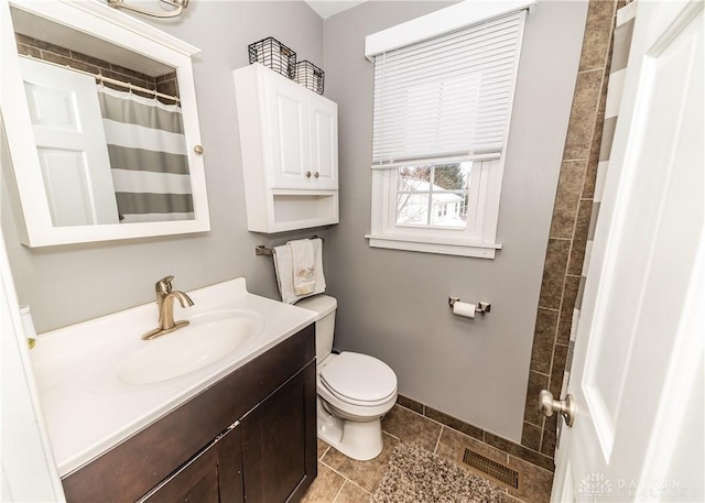 full bathroom featuring curtained shower, toilet, vanity, visible vents, and baseboards