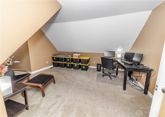 carpeted office space featuring vaulted ceiling and baseboards