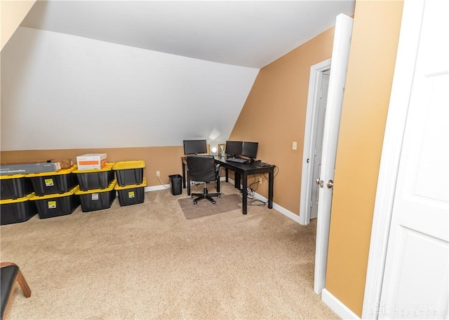 carpeted office space with lofted ceiling and baseboards