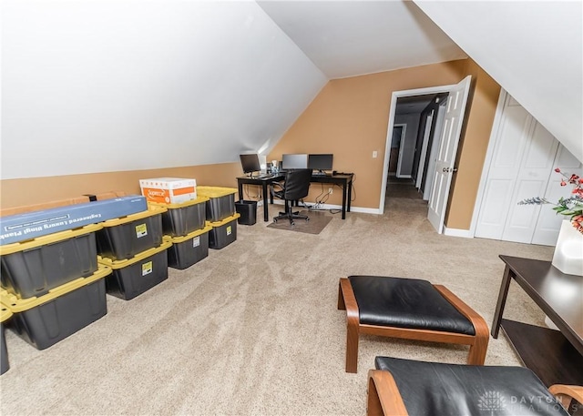 carpeted office featuring vaulted ceiling and baseboards