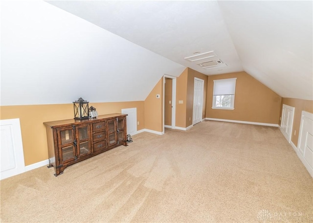 additional living space with vaulted ceiling, carpet flooring, visible vents, and baseboards