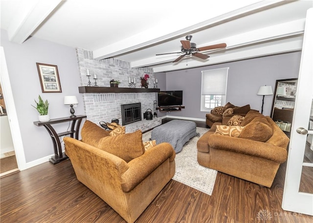 living room featuring a brick fireplace, baseboards, beamed ceiling, and wood finished floors