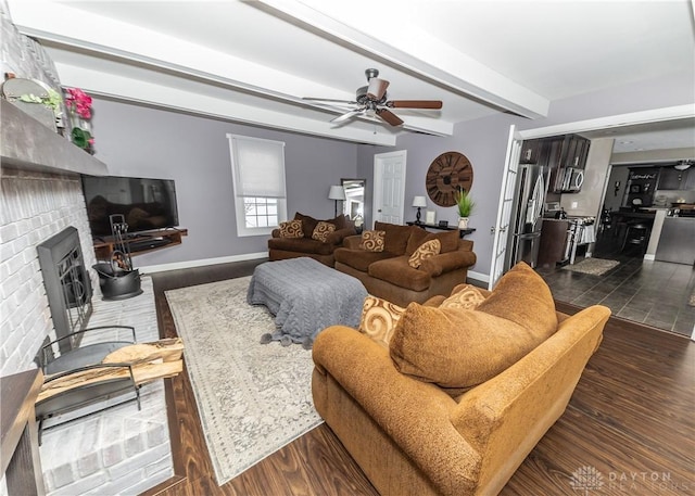 living area with dark wood-style floors, a brick fireplace, and beamed ceiling