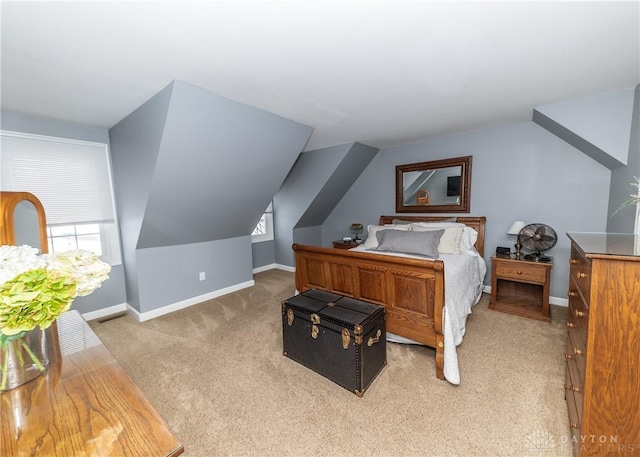 bedroom featuring lofted ceiling, light carpet, visible vents, and baseboards