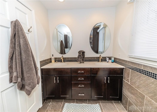 bathroom with double vanity, tile patterned flooring, tile walls, and a sink