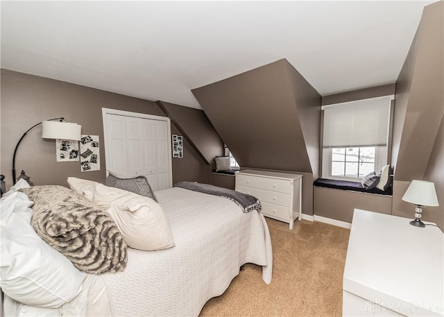 bedroom with light carpet, baseboards, and a closet