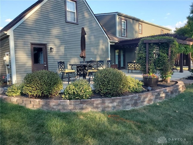 rear view of house with a lawn, a patio area, and a pergola