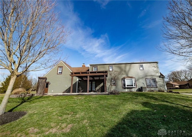 back of property featuring a chimney, cooling unit, and a lawn