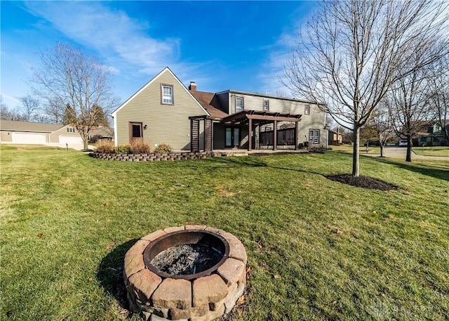 rear view of property featuring a chimney, a lawn, an outdoor fire pit, a patio area, and a pergola