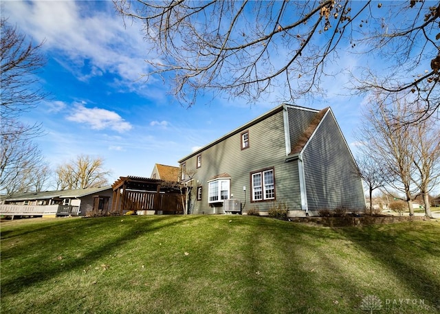 back of property with cooling unit and a yard