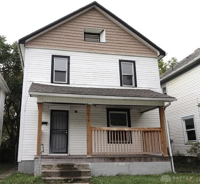 rear view of house with a shingled roof and a porch