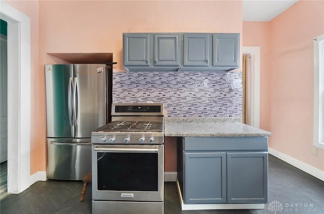 kitchen featuring gray cabinets, baseboards, stainless steel appliances, and decorative backsplash