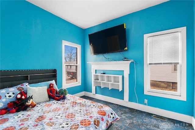 bedroom with visible vents, a fireplace, and baseboards