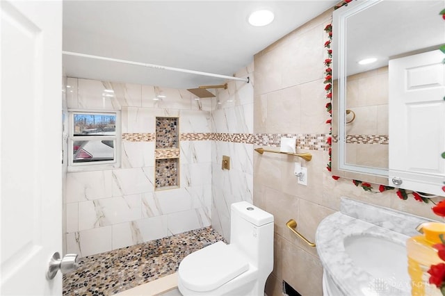 full bathroom featuring a stall shower, tile walls, toilet, and vanity