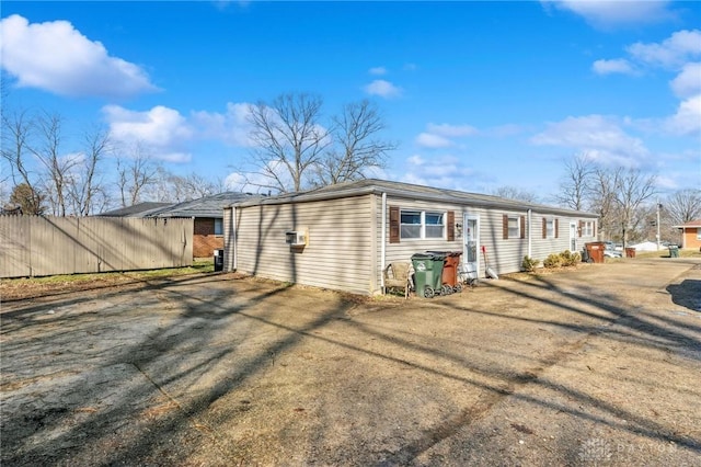 back of house featuring fence and driveway