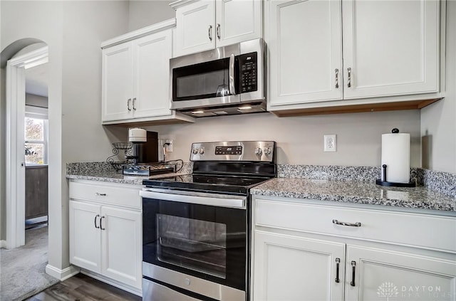 kitchen with appliances with stainless steel finishes, white cabinets, and light stone countertops