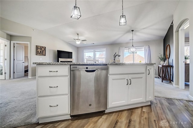 kitchen featuring white cabinets, open floor plan, hanging light fixtures, vaulted ceiling, and stainless steel dishwasher