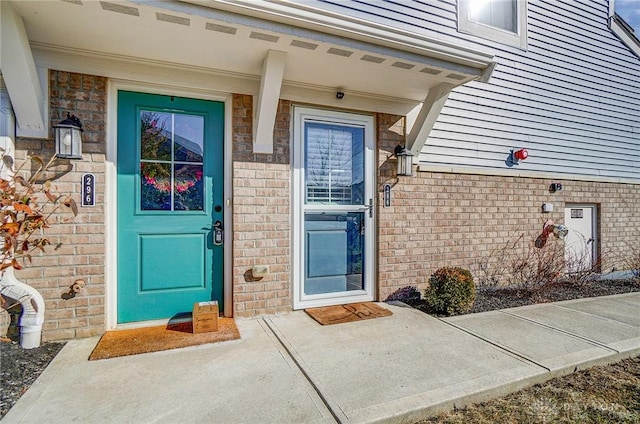 view of exterior entry with brick siding