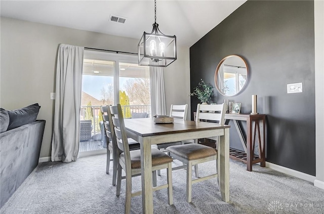 dining space featuring a notable chandelier, visible vents, light carpet, vaulted ceiling, and baseboards