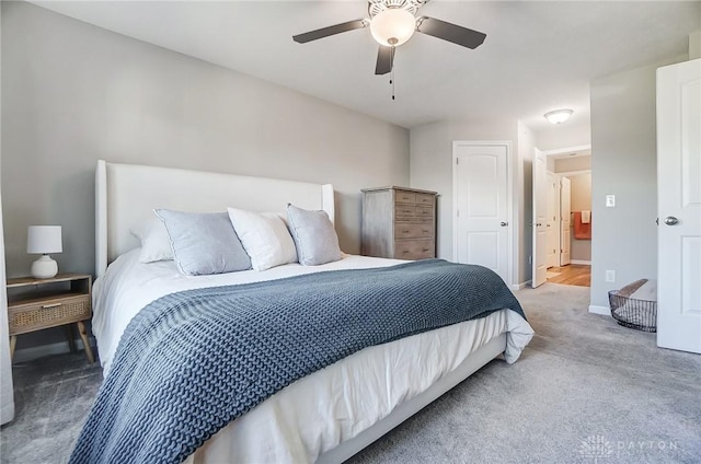 carpeted bedroom with ceiling fan and baseboards