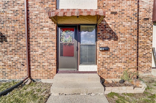 doorway to property with brick siding