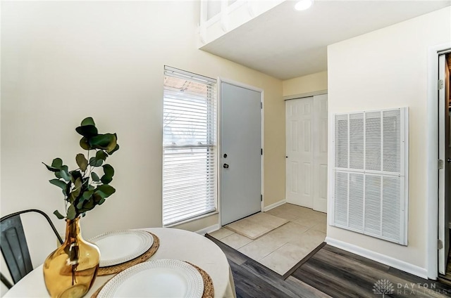 entryway featuring baseboards, a heating unit, and light wood-style flooring