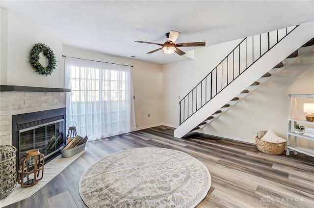 entrance foyer featuring stairs, a fireplace, visible vents, and wood finished floors