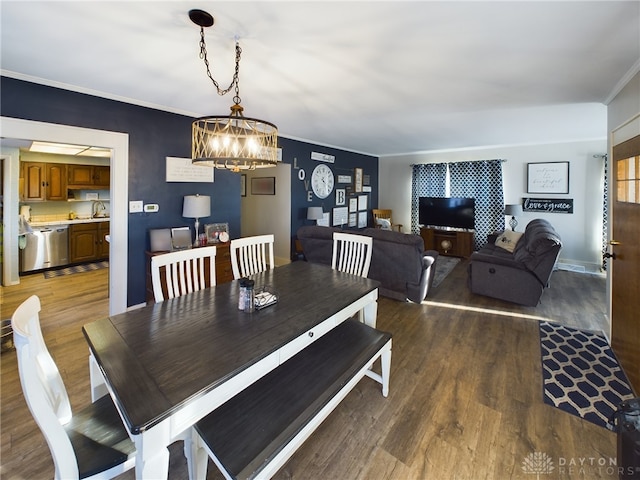 dining space with dark wood-style floors, ornamental molding, a chandelier, and baseboards