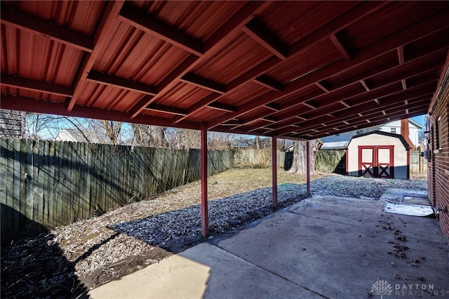 view of patio with a fenced backyard, an outdoor structure, and a storage shed