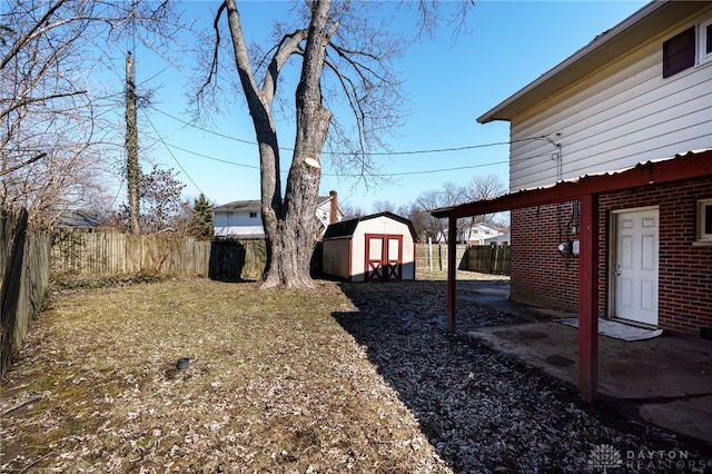 view of yard with an outbuilding, a fenced backyard, and a storage unit