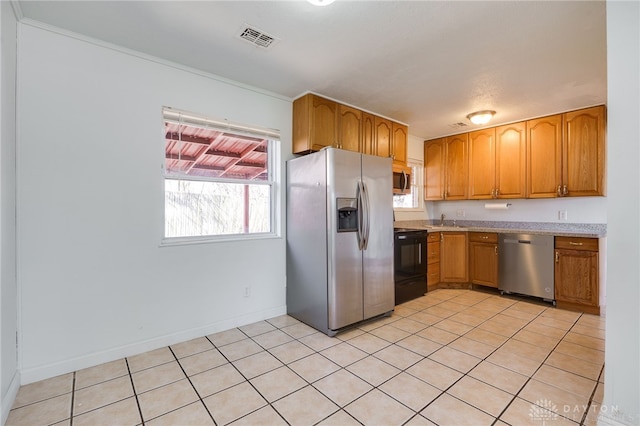 kitchen with light countertops, appliances with stainless steel finishes, brown cabinetry, and visible vents