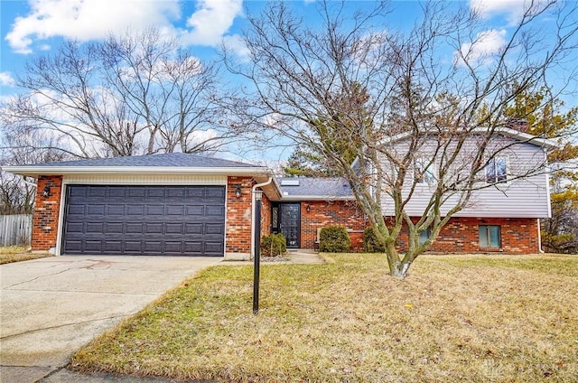 split level home featuring a garage, a front yard, brick siding, and driveway