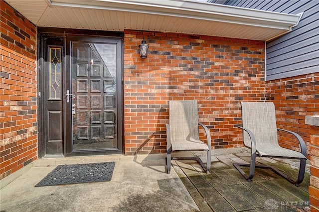 doorway to property featuring brick siding