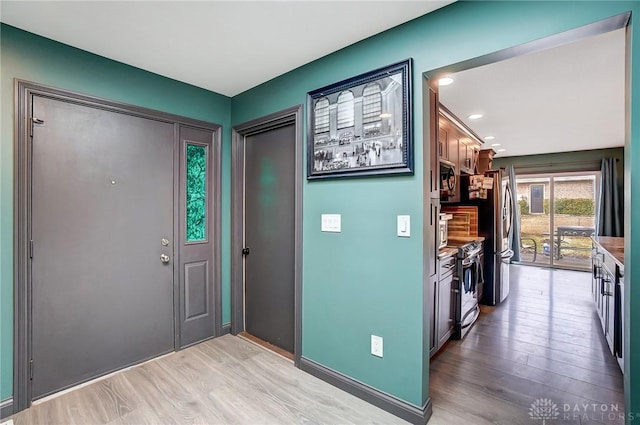 foyer with baseboards and light wood finished floors