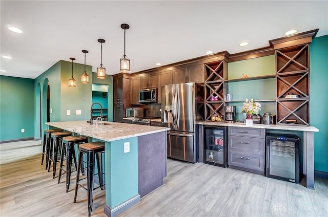 kitchen featuring arched walkways, decorative light fixtures, open shelves, stainless steel appliances, and beverage cooler