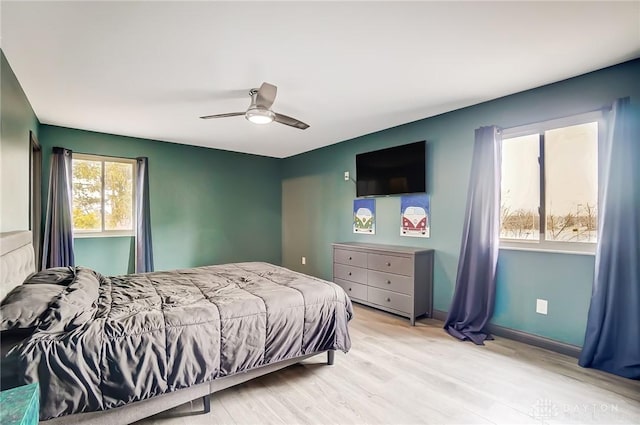 bedroom featuring light wood-style flooring, baseboards, and a ceiling fan