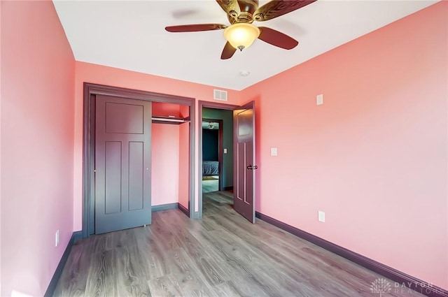 unfurnished bedroom with a closet, visible vents, light wood-style floors, ceiling fan, and baseboards