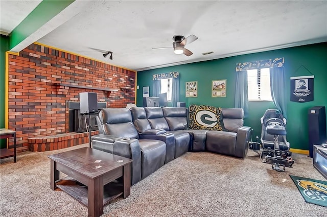 home theater room featuring ceiling fan, carpet floors, visible vents, and an accent wall