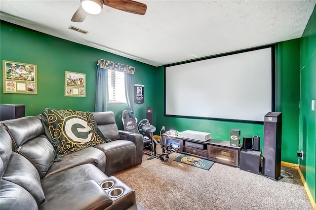 carpeted home theater featuring visible vents and ceiling fan