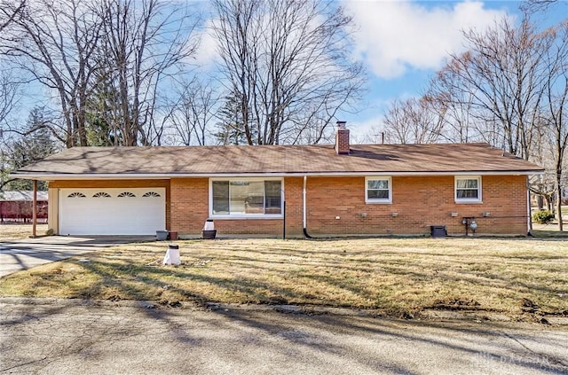 ranch-style house with concrete driveway, a chimney, an attached garage, a front lawn, and brick siding