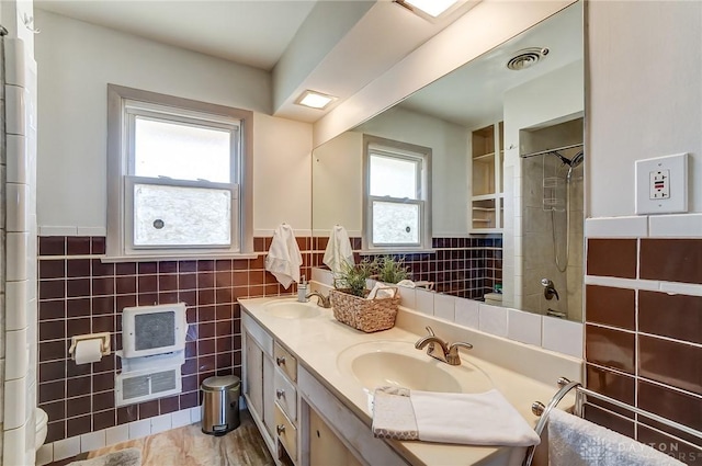 bathroom featuring double vanity, visible vents, tile walls, and a sink