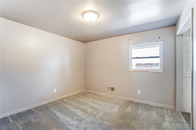 empty room featuring carpet, visible vents, and baseboards