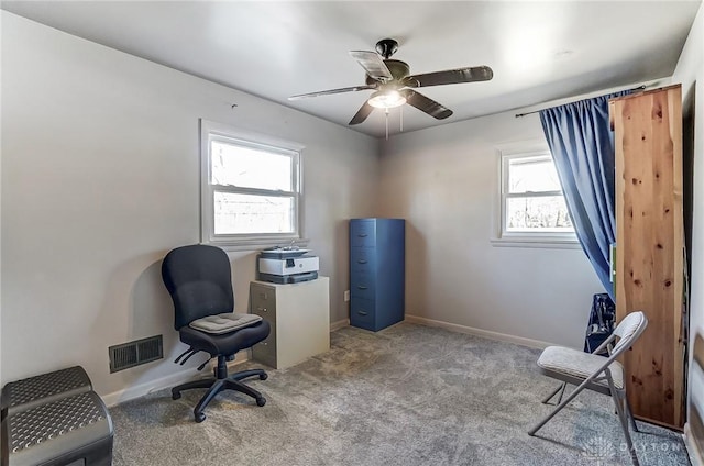 office featuring light carpet, baseboards, visible vents, and a ceiling fan