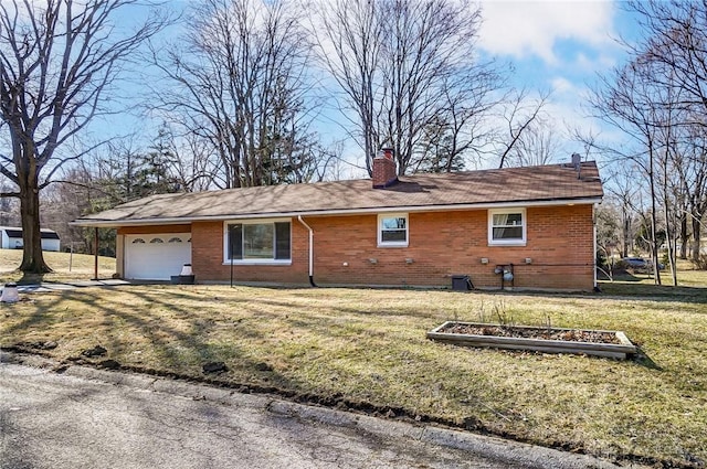 exterior space featuring a vegetable garden, a chimney, an attached garage, a front lawn, and brick siding