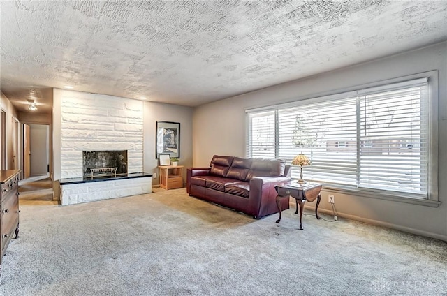 living area with baseboards, light colored carpet, a stone fireplace, and a textured ceiling