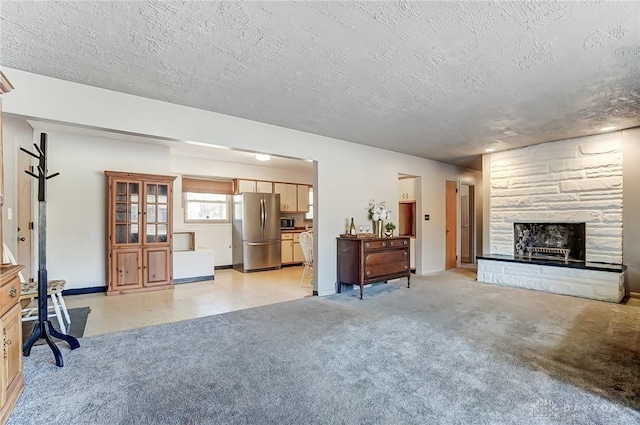 living area featuring a textured ceiling, baseboards, a stone fireplace, and light colored carpet