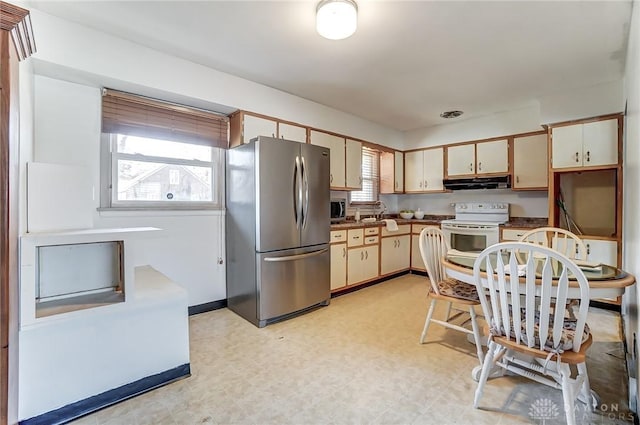 kitchen with light floors, appliances with stainless steel finishes, cream cabinets, and under cabinet range hood